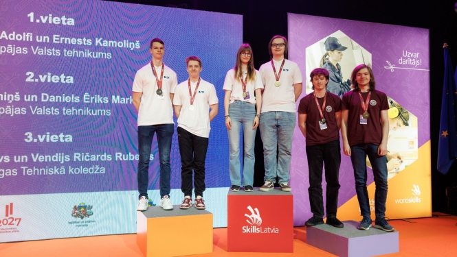 Skills Latvija 2024 konkursa uzvarētāji ar medaļām stāv uz 1.,2. un 3. vietas goda pjedestāla