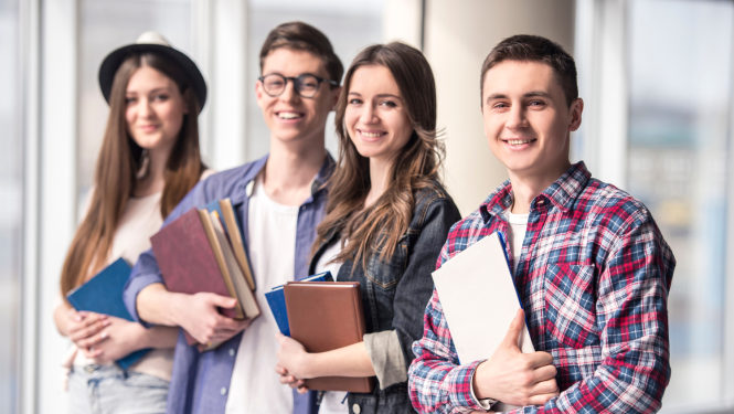 Divi studenti un divas studentes  ar grāmatām rokās