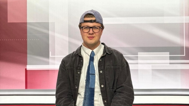 Pusis sēž pie galda televīzijas studijā