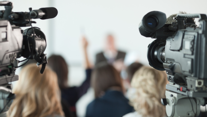 Preses konference, kameras filmē runātājus.