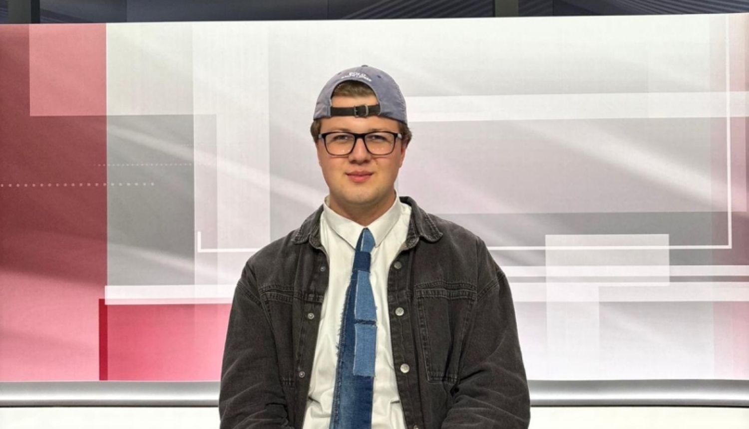 Pusis sēž pie galda televīzijas studijā
