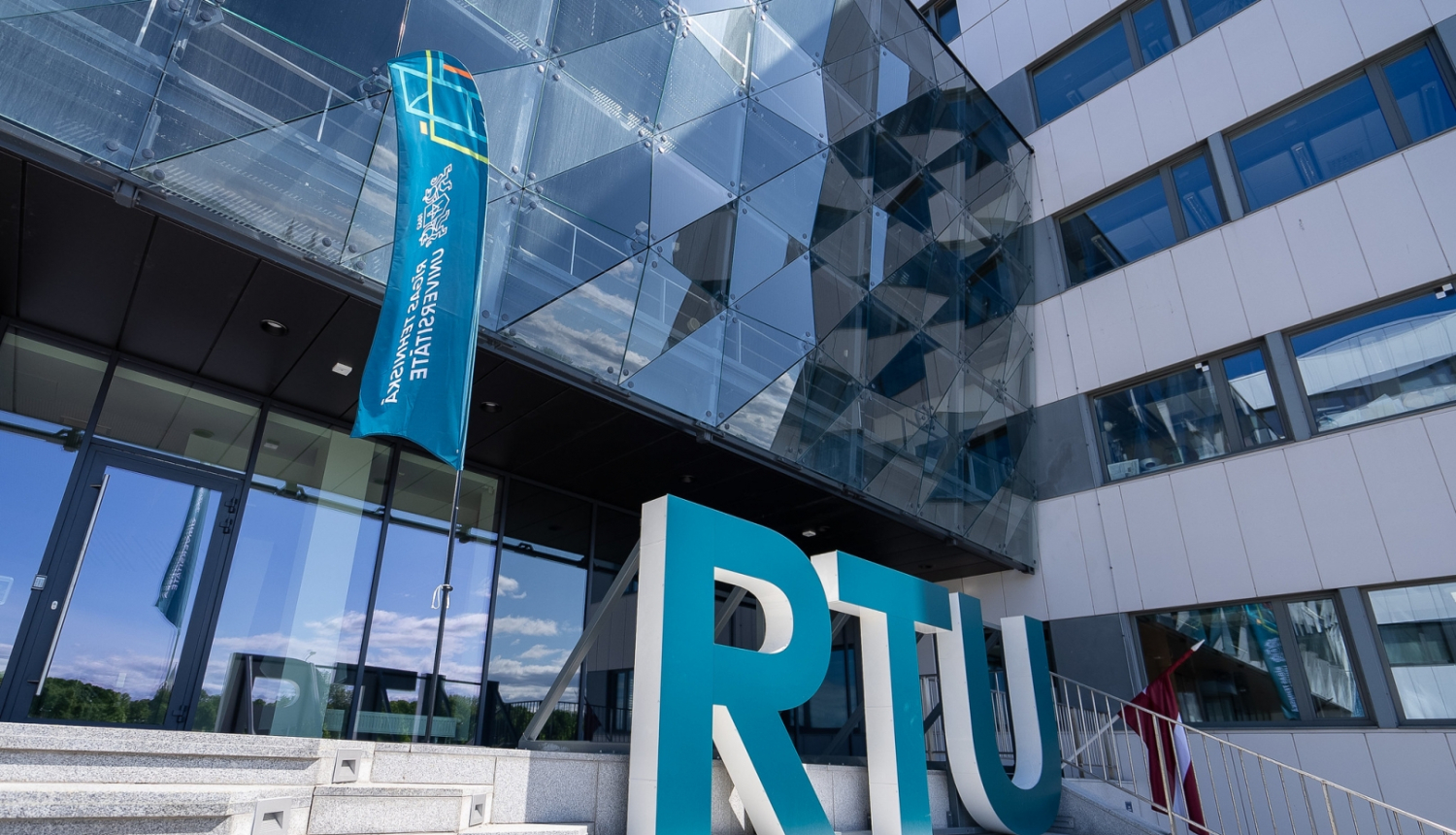 RTU ēkas kāpnes, uz kurām izvietoti lieli zaļi burti RTU