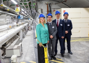Premjerministre Evika Siliņa un citi Latvijas delegācijas pārstāvji zilās kiverēs stāv CERN telpās.