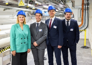 Premjerministre Evika Siliņa un citi Latvijas delegācijas pārstāvji zilās kiverēs stāv CERN telpās.
