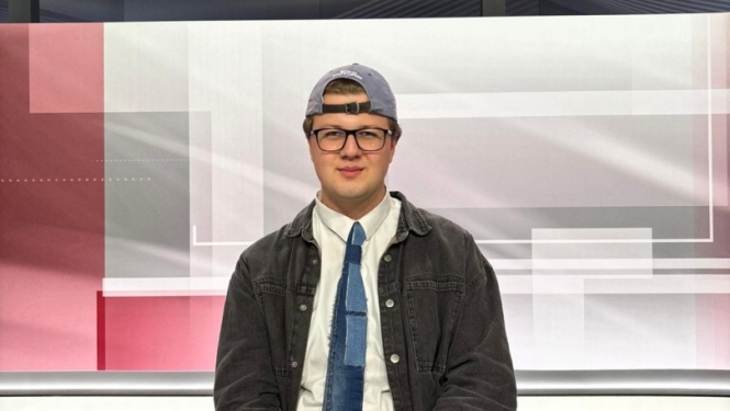 Pusis sēž pie galda televīzijas studijā
