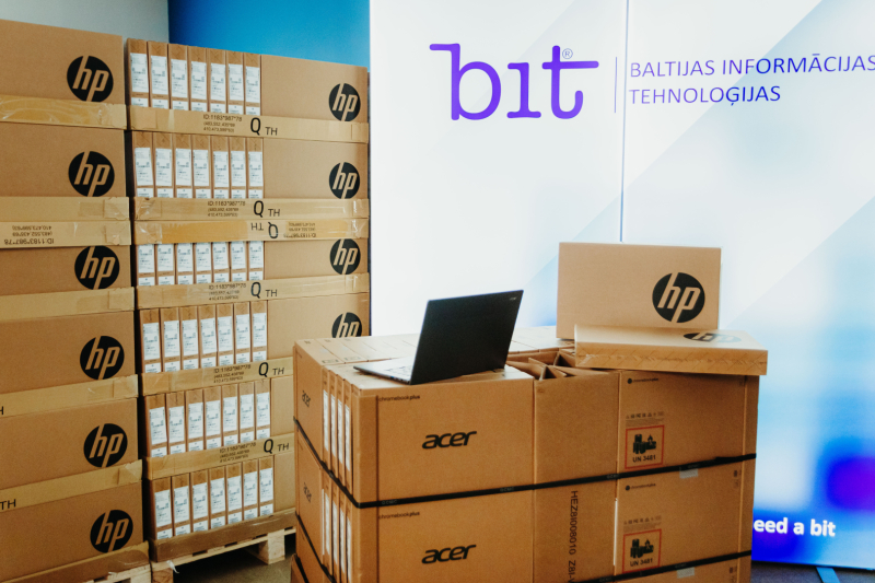 Bit logo, kastēs stāv portatīvie datori
