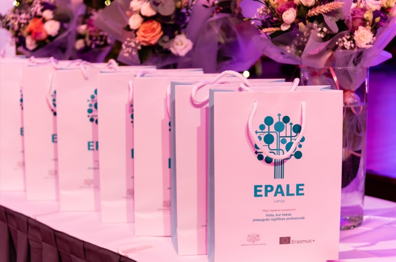 maisiņi uz galda ar Epale logo un fonā ziedi