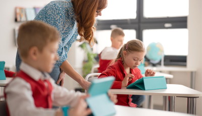 Bērni sēž klasē pie planšetdatoriem