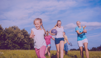 Bērni ar pieagušajiem sporto saulainos laikapstākļos