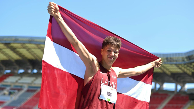 Latvijas Jaunatnes olimpiādes sportists ar Latvijas karogu rokās