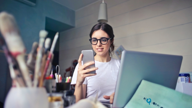 Skolniece skatās telefonā
