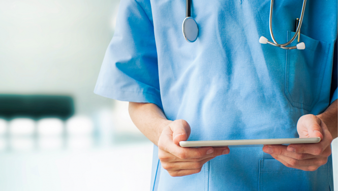 Medicīnas darbinieka rokas, kas tur rokās planšeti