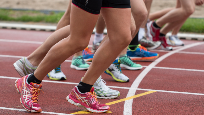 Skrienošu cilvēku kājas un sporta apavi