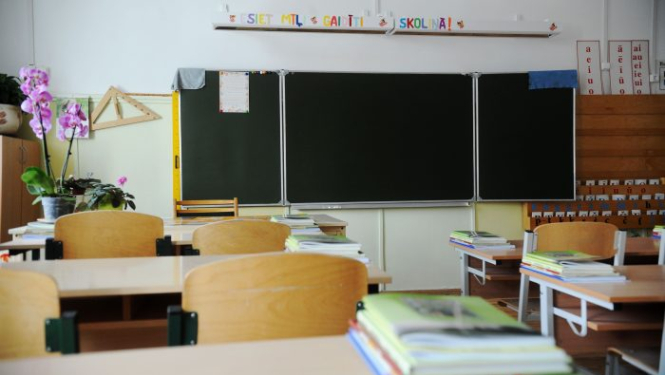 Klase ar skolas soliem, uz sienas redzama tāfele.