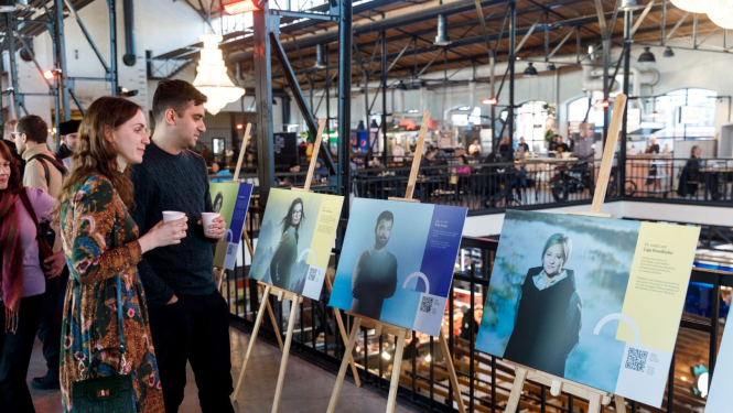 cilvēki vēro izstādi