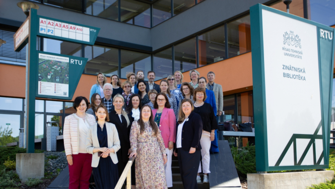 Semināra dalībnieki stāv uz kāpnēm