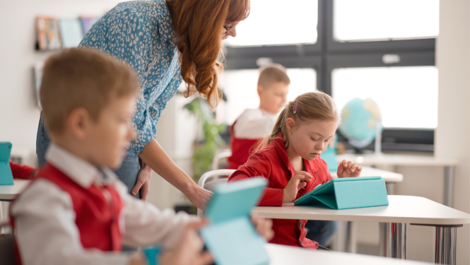 Bērni sēž klasē pie planšetdatoriem