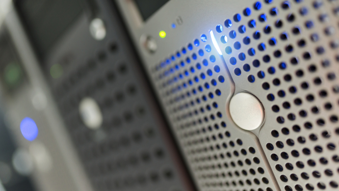 Stacionārie datori salikti rindā, dažos no tiem spīd darbošanās gaisma