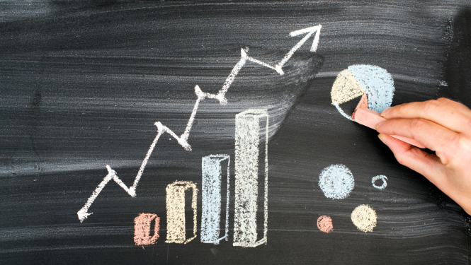 Ar krītiņiem uz tāfeles uzzīmēts augošs grafiks un bulta uz augšu