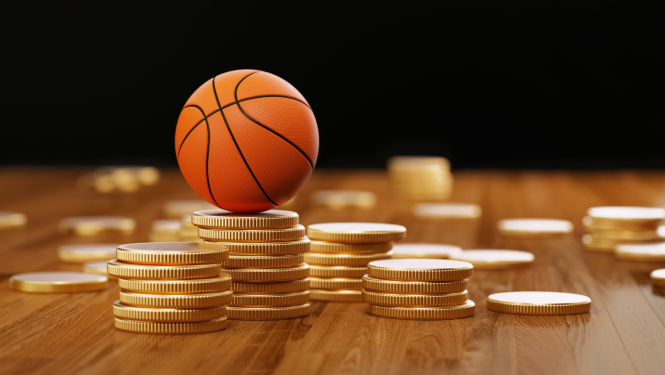 Izkaisītas naudas monētas uz galda, uz vienas no kollonām – basketbola bumba.