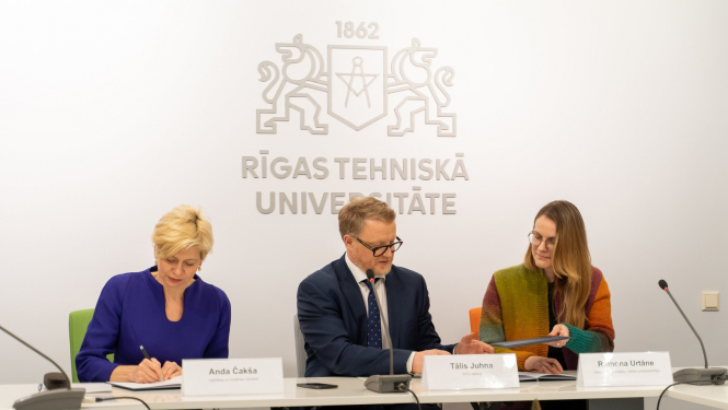 Anda Čakša, Tālis Juhna un Ramona Urtāne sēž pie galda memoranda parakstīšanā