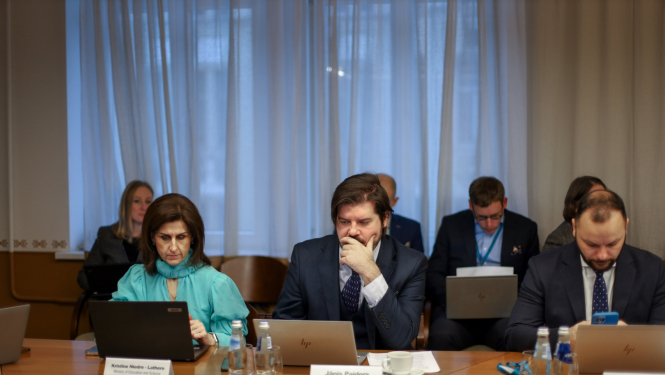 Jānis Paiders un Kristīne Niedre-Lathere sēž pie galda sanāksmē