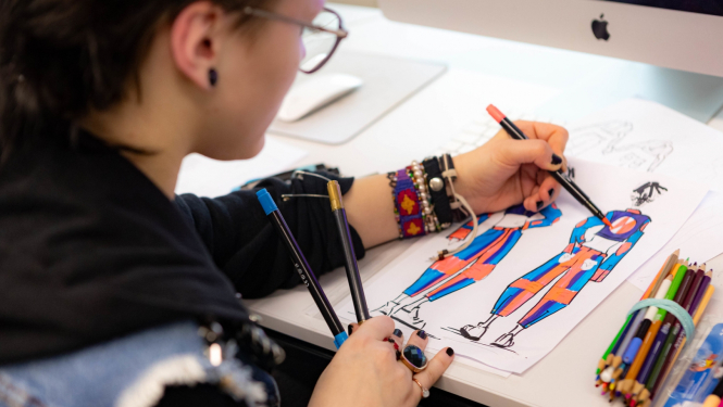 SkillsLatvia konkursa pusfinālā meitene zīmē tērpu skices