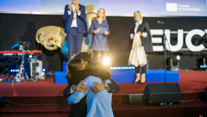 Cilvēki apskāvušies pie EUCYS 2025 skatuves