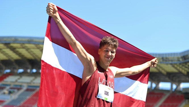 Latvijas Jaunatnes olimpiādes sportists ar Latvijas karogu rokās