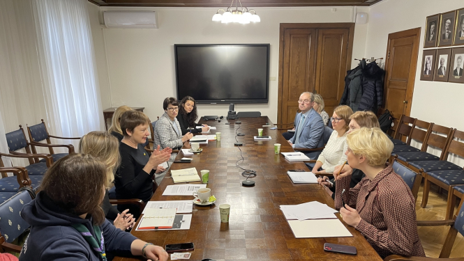 cilvēki sarunājas pie galda