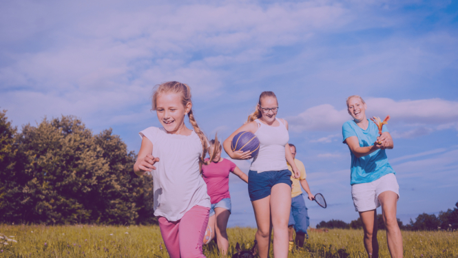 Bērni ar pieagušajiem sporto saulainos laikapstākļos