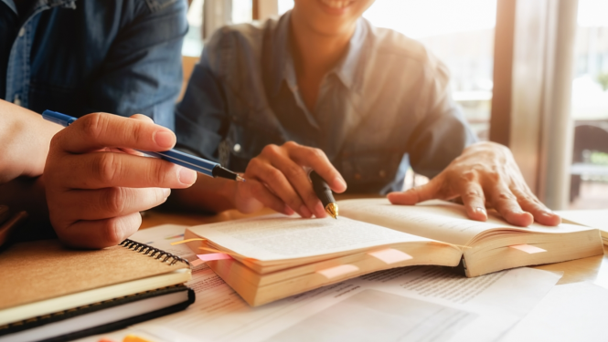 Cilvēki pēta grāmatu un diskutē