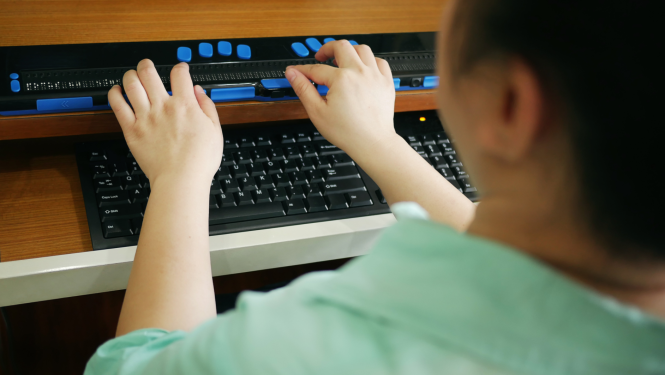 Bērns izmanto braila displeju