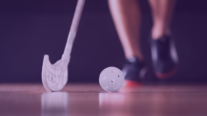 Spotists tur rokās florbola nūju un sit pa bumbiņu