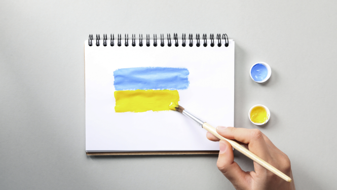 Cilvēks zīmē Ukrainas karogu