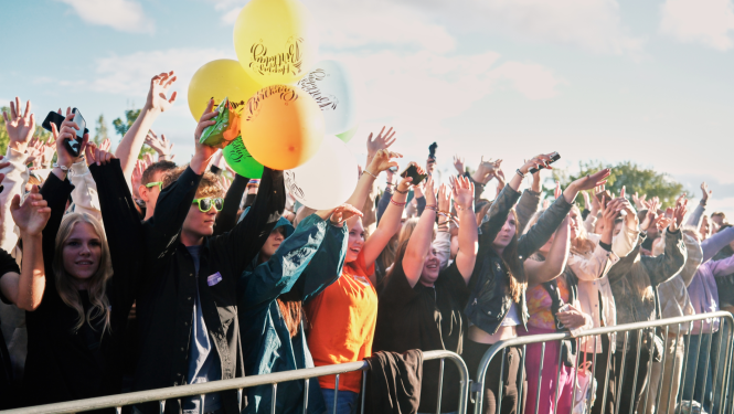 Jaunieši ar paceltām rokām un baloniem