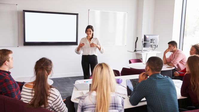Pedagogs runā klases priekšā
