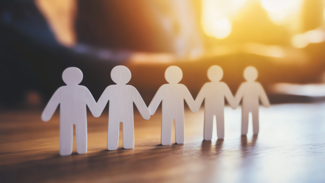 Papīra cilvēciņi sadevušies rokās, nolikti uz galda