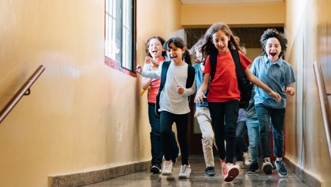 Bērni laimīgi skrien pa skolu