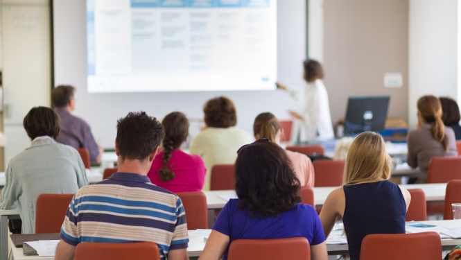Studenti mācas auditorijā, lektors rāda prezentāciju.