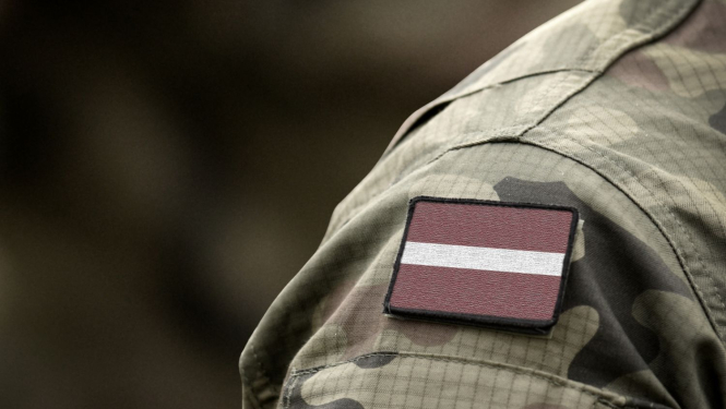 Karavīra uniforma ar piespraustu Latvijas karogu uz pleca
