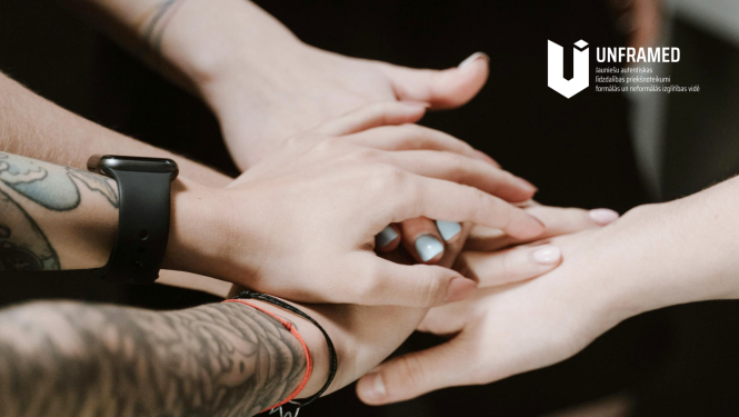 Kopā saliktas rokas. "UNFRAMED" logo