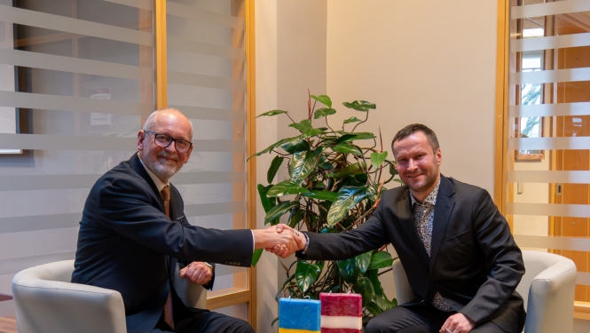 Rīgas Stradiņa universitātes rektors Aigars Pētersons un Latvijas Sporta pedagoģijas akadēmijas rektors Kalvis Ciekurus spiež viens otram roku 