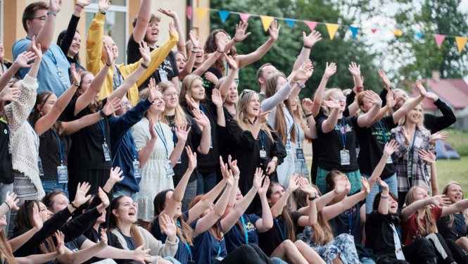 Daudz priecīgu jauniešu pacēluši rokas