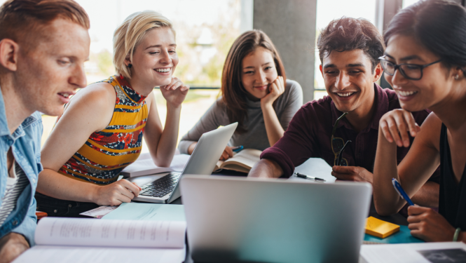 Pieci studenti sēž pie galda un skatās portatīvā datora ekrānā