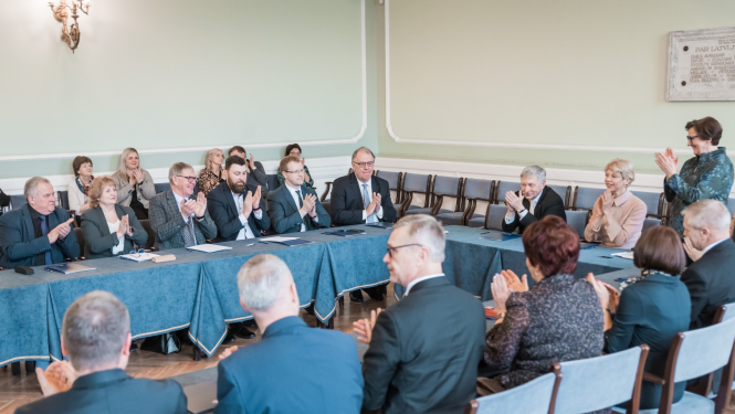 IZM un LU memoranda parakstīšana ar pašvaldībām. Cilvēki sēž ap lielu galdu LU Mazajā aulā