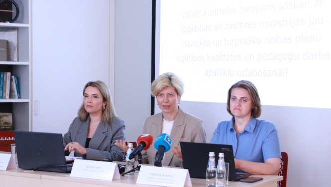 Ilze Saleniece, Anda Čakša un Edīta Kanaviņa sēž pie gada un runā. Uz galda mediju mikrofoni. 