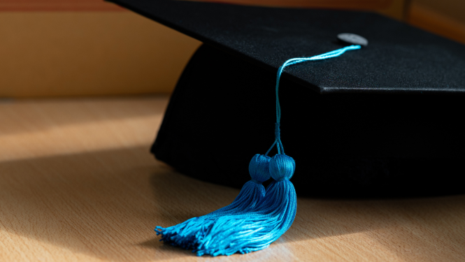 Melna absolventa cepure ar zilu bārkstiņu