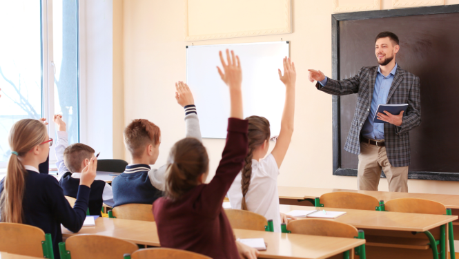 Klasē skolotājs jautā skolēniem un skolēni ceļ rokas
