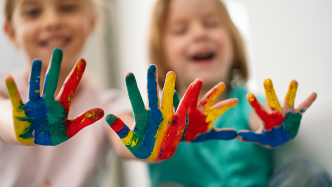 Bērni izstiepuši rokas, rokas apzīmētas ar dažādām krāsām 